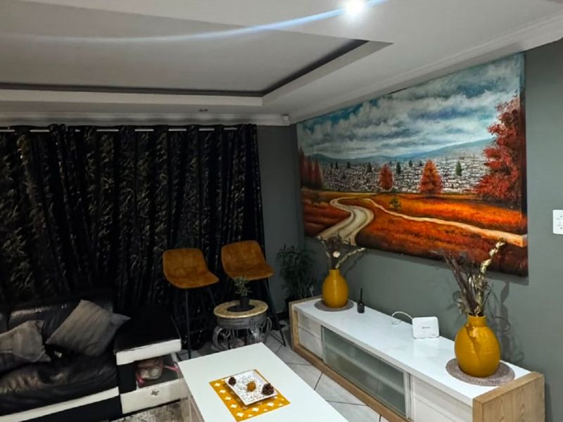 A living room featuring a recessed ceiling design and tiled flooring, providing a comfortable and well-maintained space for relaxation.