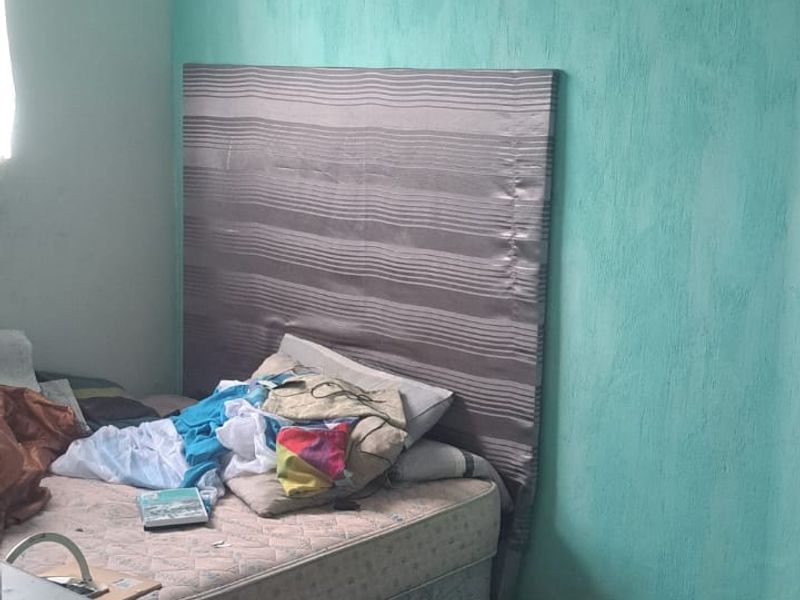 A bedroom featuring tiled flooring and textured walls, currently requiring maintenance and cosmetic updates to improve its overall condition and appeal.