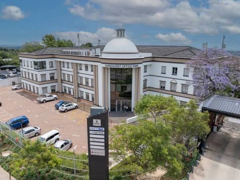 Aerial view of Sandhurst Office Park featuring a prominent domed entrance, multi-story commercial building, and dedicated paved parking area.