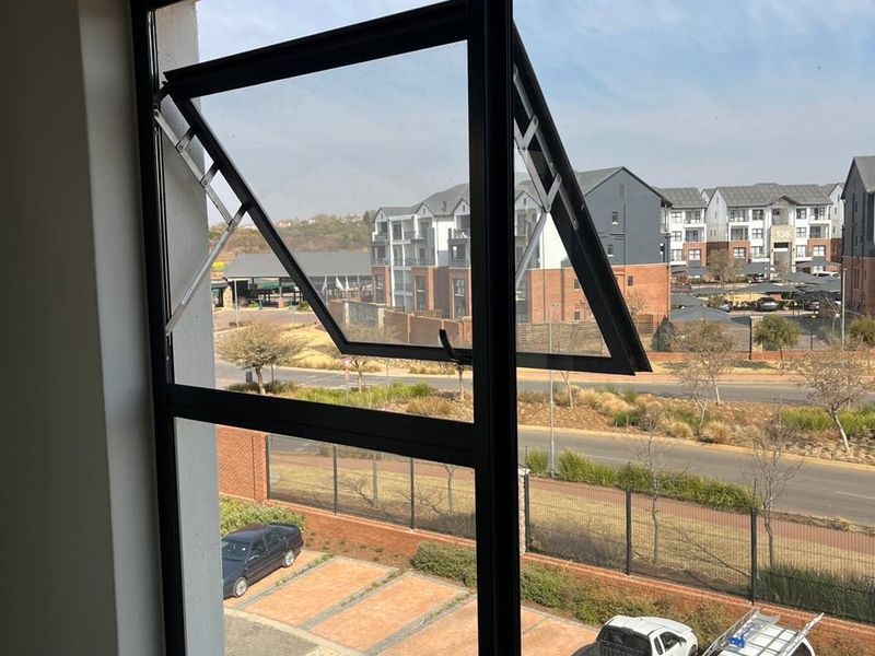 A view from an interior window looking out over a parking area and neighbouring residential apartment complex.