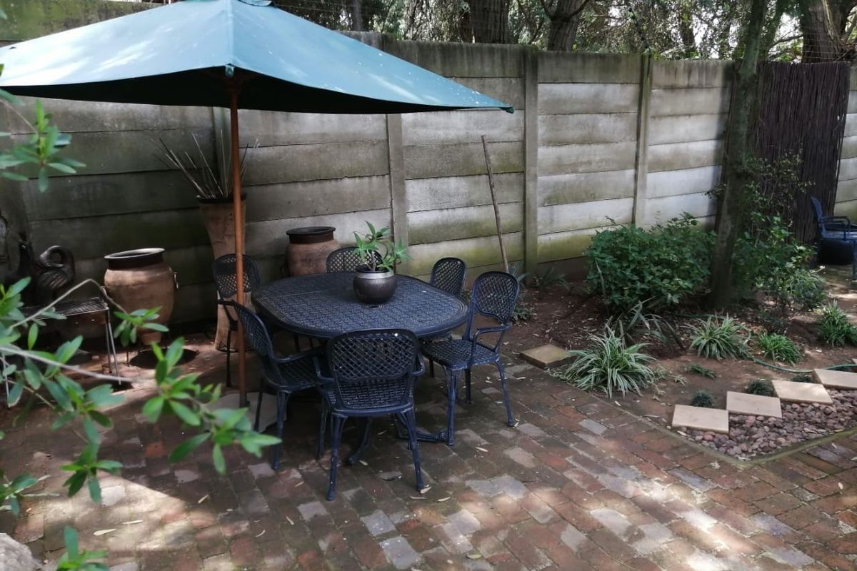 A private rear garden area featuring brick paving and a precast concrete boundary wall, providing a quiet outdoor space.