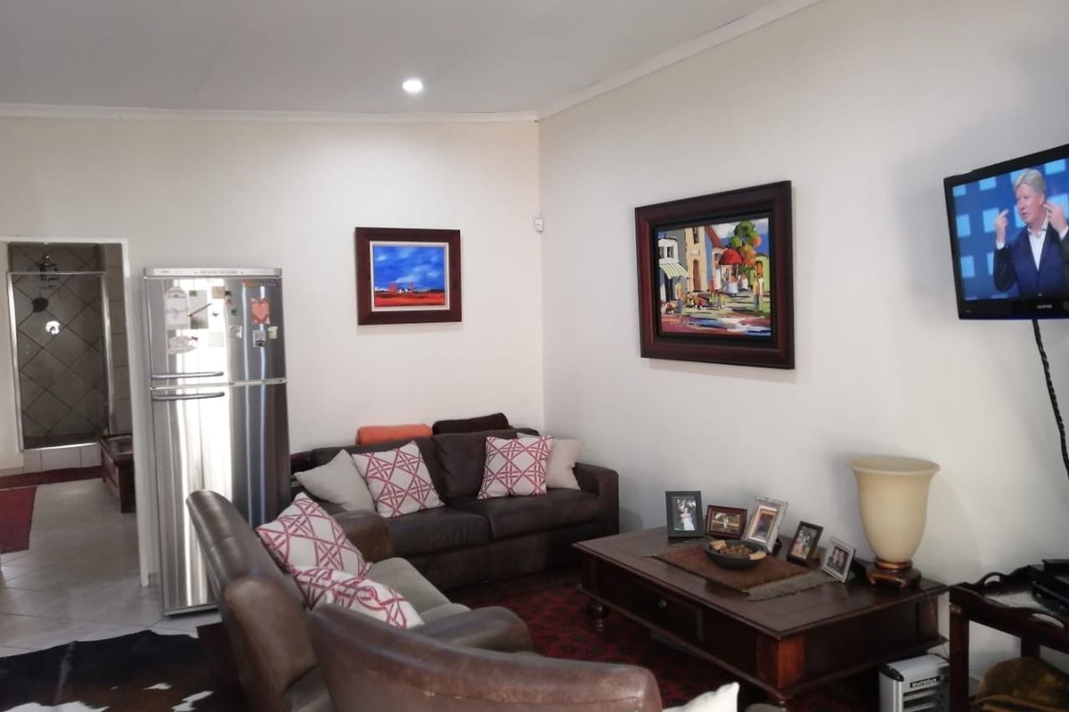 A comfortable living room area featuring tiled flooring and recessed downlighting, providing a functional space for relaxation.