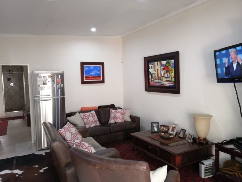 A comfortable living room area featuring tiled flooring and recessed downlighting, providing a functional space for relaxation.