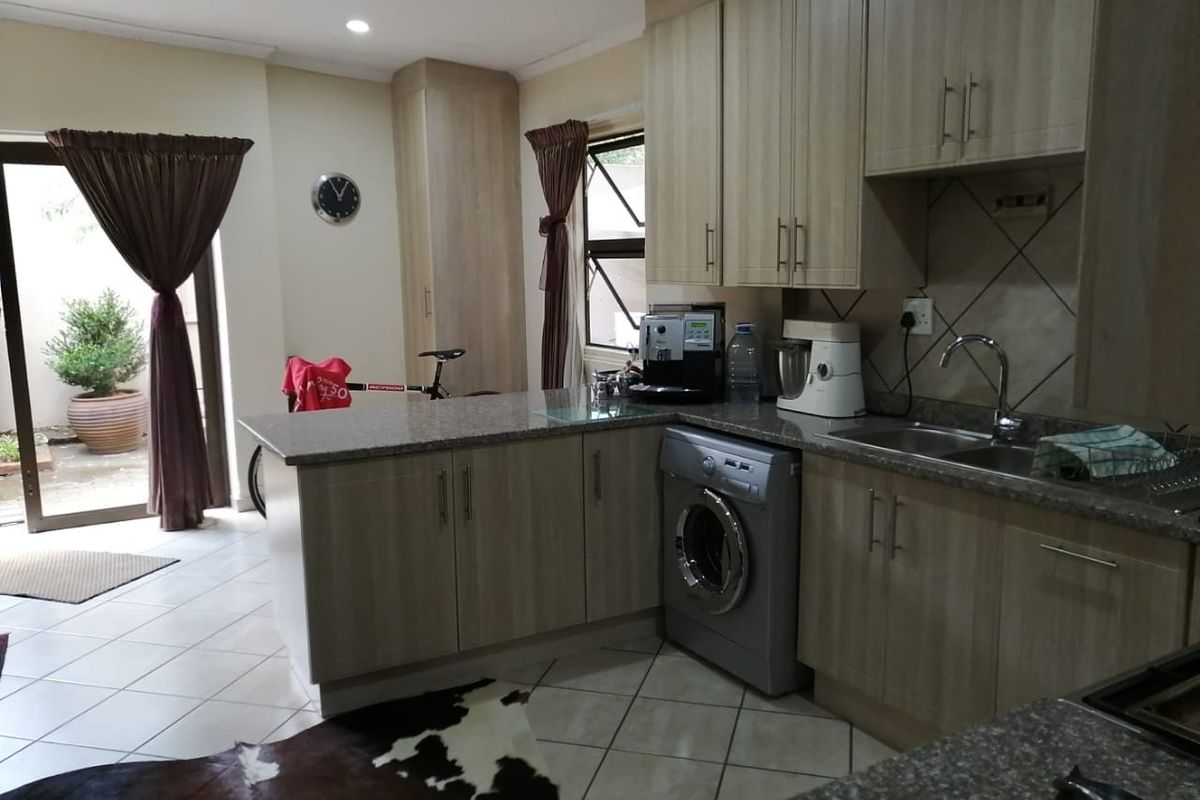 Functional kitchen featuring granite countertops, ample cabinetry, and direct access to an outdoor patio area through a sliding glass door.