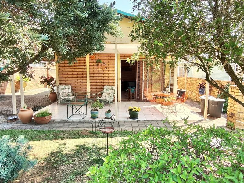 A covered outdoor patio area featuring brick wall finishes and tiled flooring, providing a functional space for outdoor relaxation and entertaining.