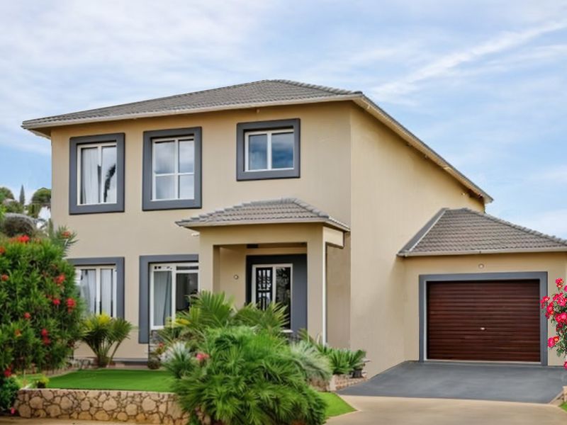 A well-maintained two-story suburban home featuring a neutral facade, tiled roof, integrated garage, and landscaped front garden with stone retaining wall.