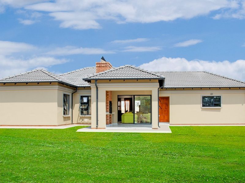 Rear view of a modern single-story house featuring a covered patio with a built-in braai, tiled roof, and expansive lawn.