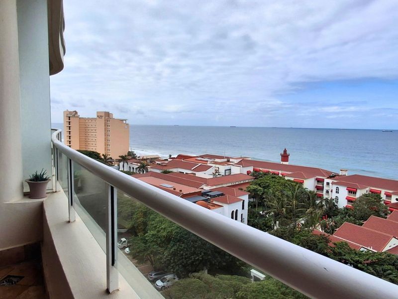 A balcony featuring a glass balustrade with expansive coastal and ocean views.