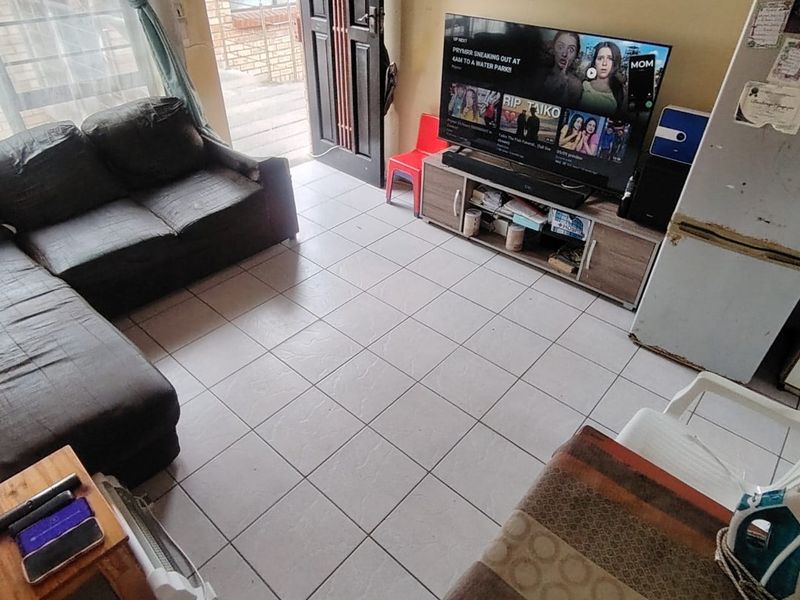Open plan living area featuring tiled flooring and direct access to an outdoor balcony through a sliding door.