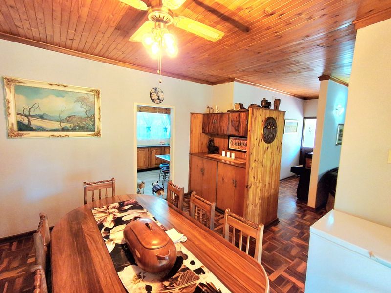Dining room featuring parquet flooring, a wooden ceiling with a ceiling fan, and built-in wooden cabinetry, with an open transition to the kitchen area.