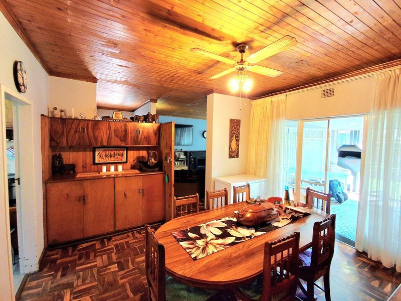 Dining room featuring warm timber ceilings, parquet flooring, and built-in wooden cabinetry, with direct access to an outdoor patio area.
