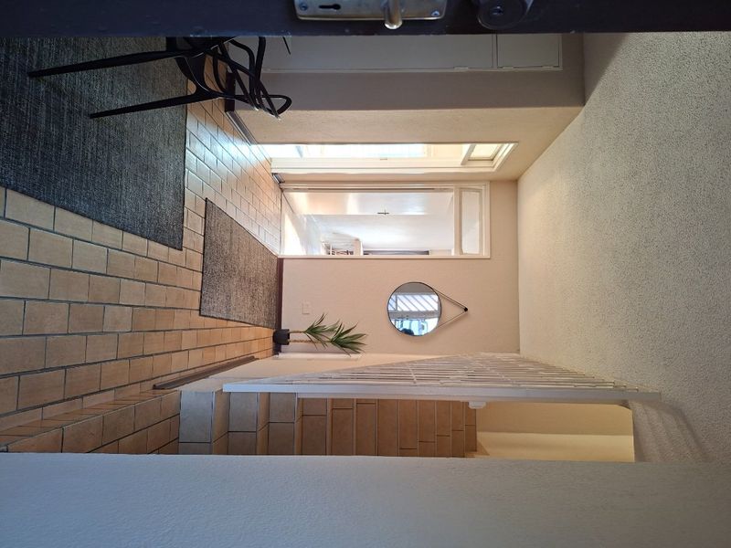 Entrance area featuring tiled flooring and a security gate, providing access to the interior living spaces of the apartment.