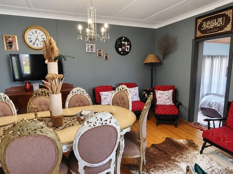 A well-maintained dining room featuring polished hardwood flooring, a decorative crystal chandelier, and coved ceiling details, providing a warm and inviting atmosphere.