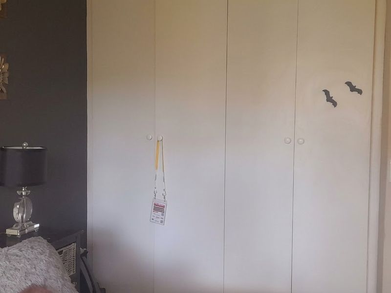 A bedroom featuring built-in cupboards and an internal door, providing functional storage and access within the living space.