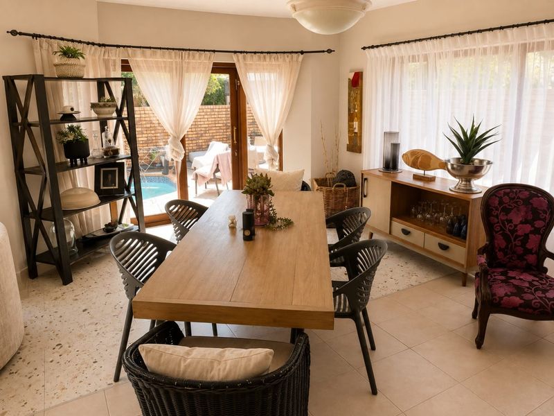 Bright dining room featuring terrazzo flooring and large sliding glass doors providing direct access to the outdoor pool area.