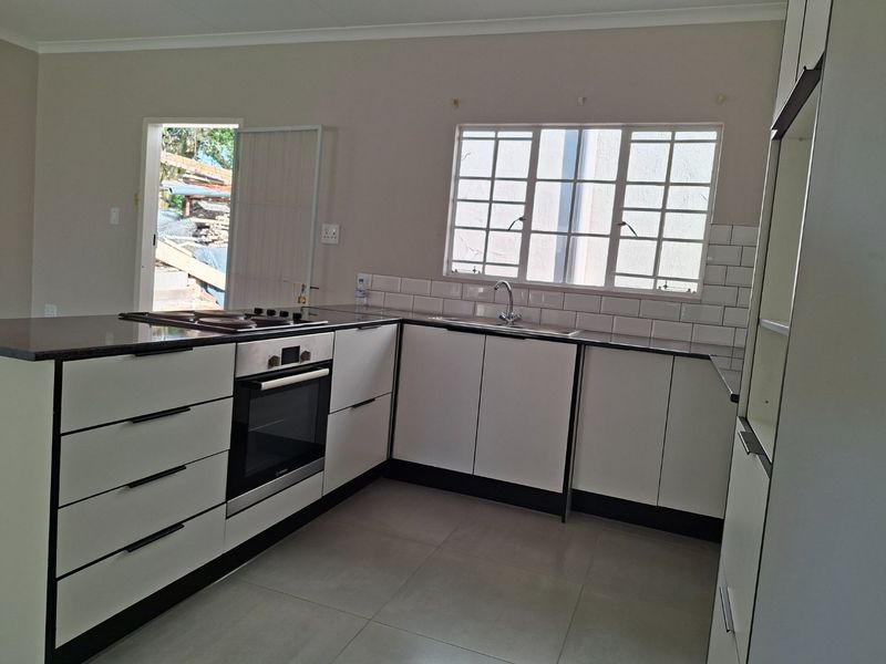Modern kitchen featuring white cabinetry, subway tile backsplash, built-in oven, gas hob, and tiled flooring, offering a clean and functional workspace.