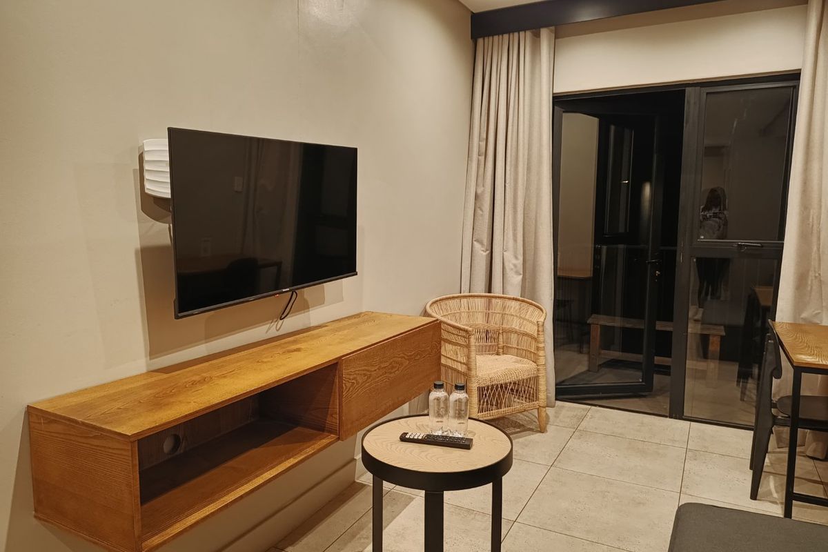 A modern living area featuring tiled flooring, recessed lighting, and a sliding glass door providing access to an outdoor space.