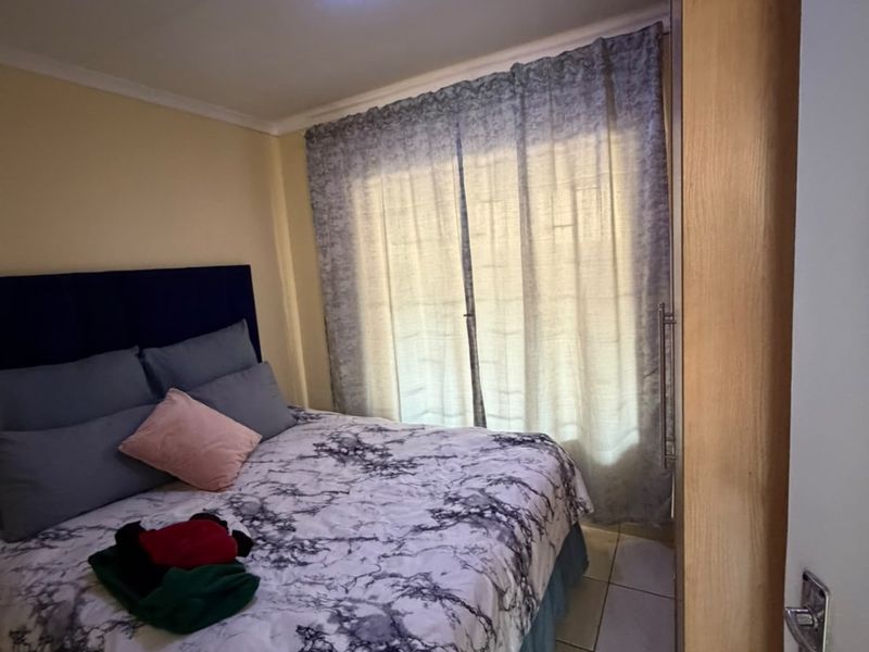 A functional bedroom featuring tiled flooring, a built-in cupboard, and a ceiling light fixture, offering a practical space for rest.
