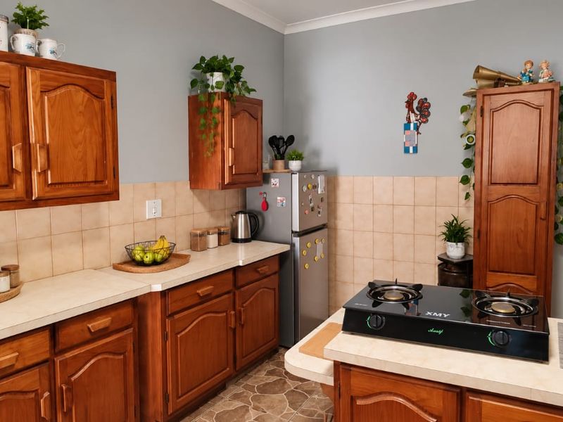A functional kitchen featuring traditional wooden cabinetry, laminate countertops, a tiled backsplash, and a built-in gas cooktop.