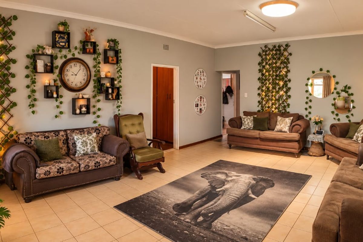 Spacious living room featuring neutral wall tones, tiled flooring, and coving, providing a comfortable and versatile area for relaxation.