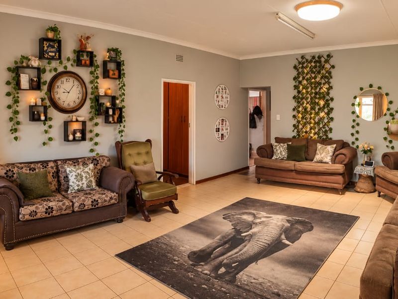 Spacious living room featuring neutral wall tones, tiled flooring, and coving, providing a comfortable and versatile area for relaxation.