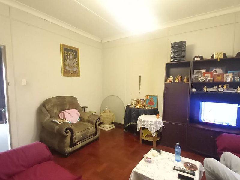 A living room featuring parquet flooring and coved ceilings, providing a functional space for relaxation.