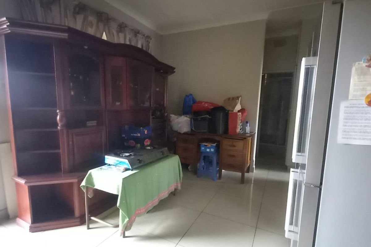A living area featuring tiled flooring and coved ceiling details, offering a functional space that could benefit from modern updates and improved lighting.