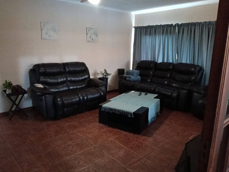 A living room featuring tiled flooring and a ceiling fan, providing a functional space for relaxation.