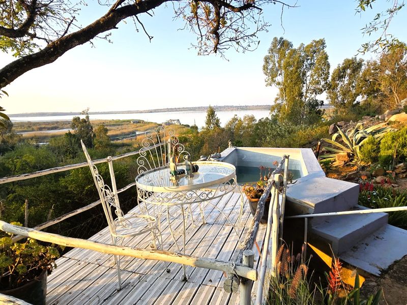 Outdoor deck area featuring a small plunge pool with scenic lake views and natural landscape surroundings.