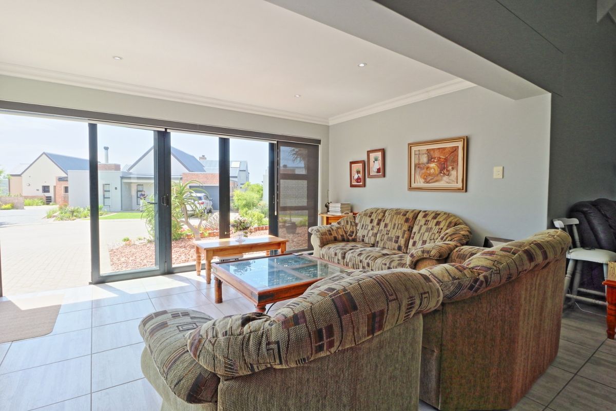 A bright living room featuring large sliding glass doors that provide ample natural light and direct access to the exterior.
