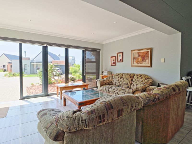 A bright living room featuring large sliding glass doors that provide ample natural light and direct access to the exterior.