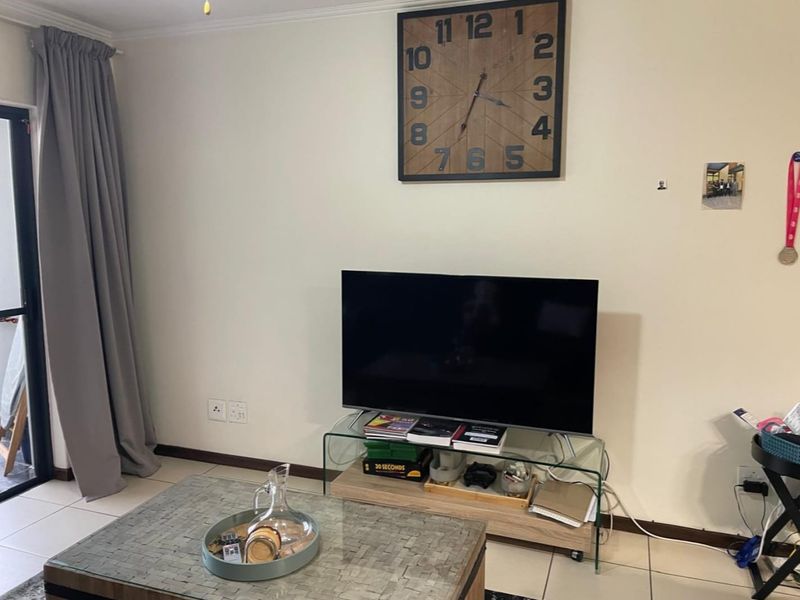 A living room area featuring tiled flooring and a sliding glass door providing access to the exterior.