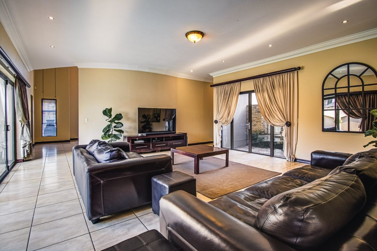 Spacious living room featuring tiled flooring, recessed downlighting, and large sliding glass doors that provide access to the outdoor area.