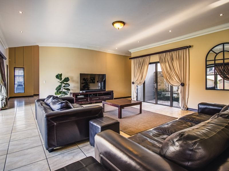 Spacious living room featuring tiled flooring, recessed downlighting, and large sliding glass doors that provide access to the outdoor area.