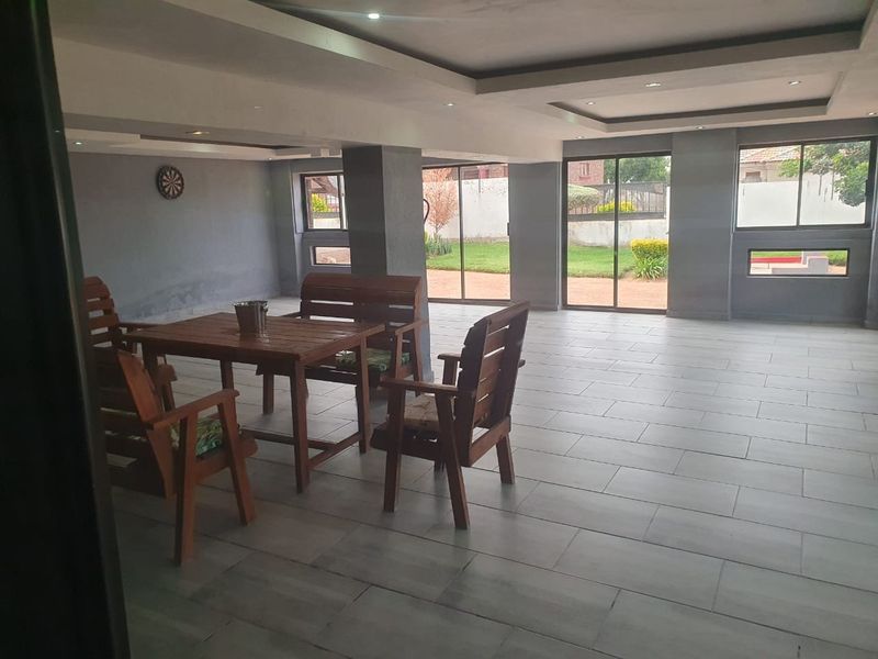 Spacious living area featuring tiled flooring, recessed ceiling lighting, and large sliding glass doors providing direct access to the rear garden.