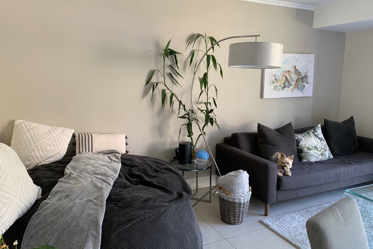 A comfortable living room area featuring neutral wall tones and tiled flooring, providing a relaxed and inviting space.