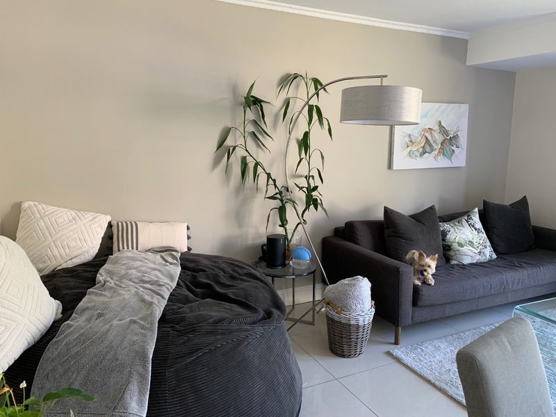 A comfortable living room area featuring neutral wall tones and tiled flooring, providing a relaxed and inviting space.
