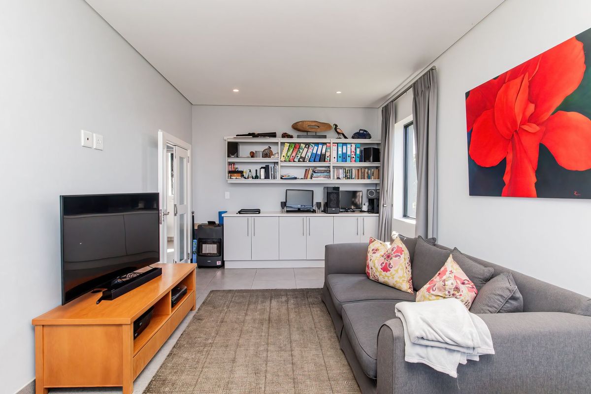 A well-maintained living room featuring built-in cabinetry and shelving, tiled flooring, and recessed lighting, providing a functional and organized space.