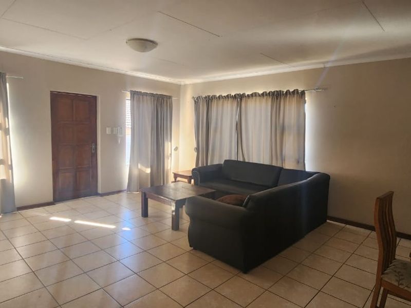 Open-plan living and dining area featuring tiled flooring and natural light, providing a functional space ready for modern updates and cosmetic improvements.
