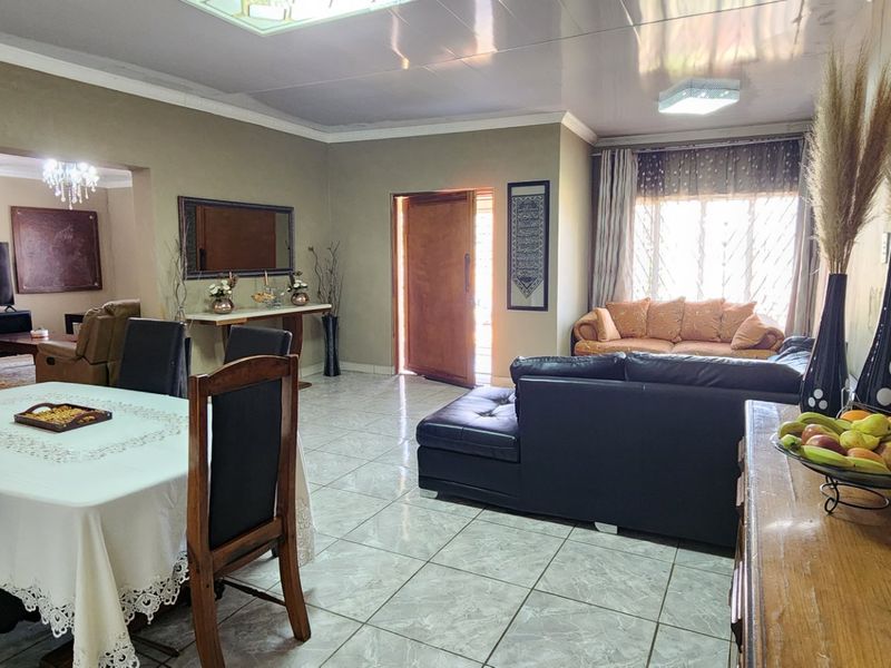 Spacious open-plan living and dining area featuring tiled flooring, coved ceilings, and natural light, providing a versatile layout for family living.