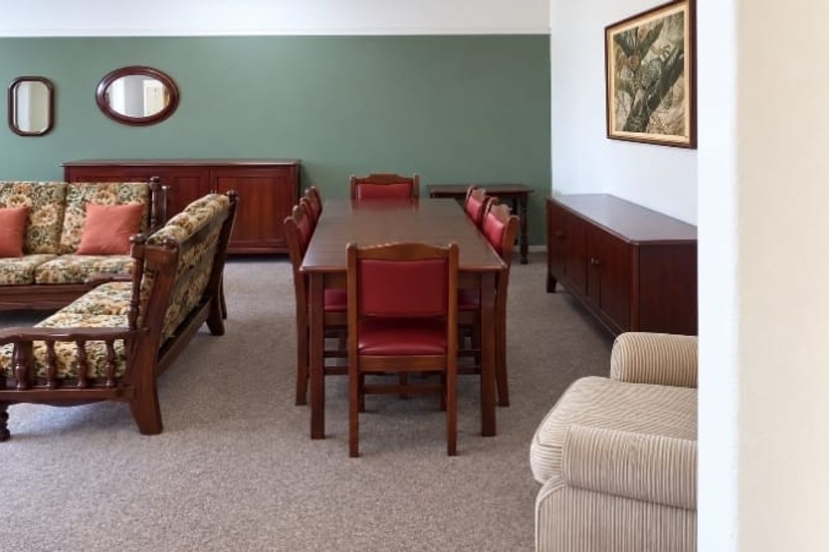 Spacious open-plan living and dining area featuring neutral carpeting and a dual-tone wall finish.