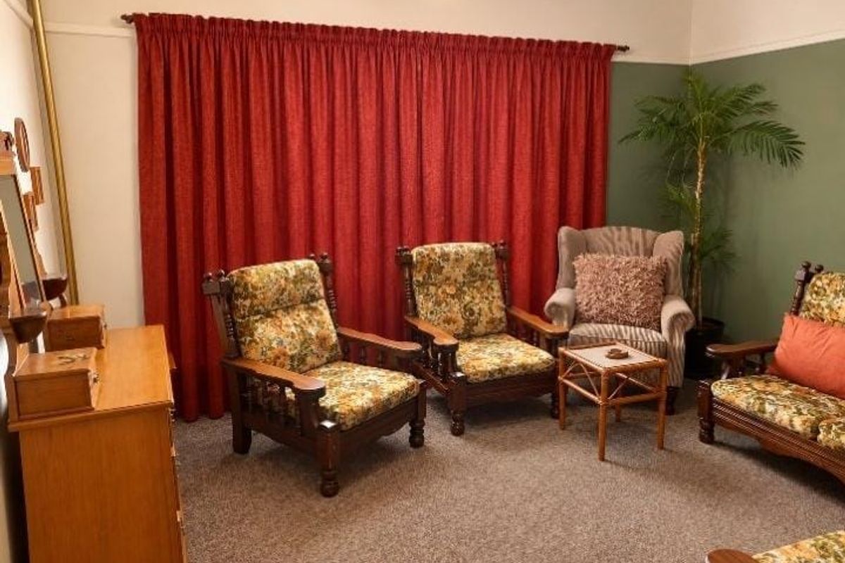 A living room featuring carpet flooring and a classic picture rail, providing a neutral base for potential interior updates.