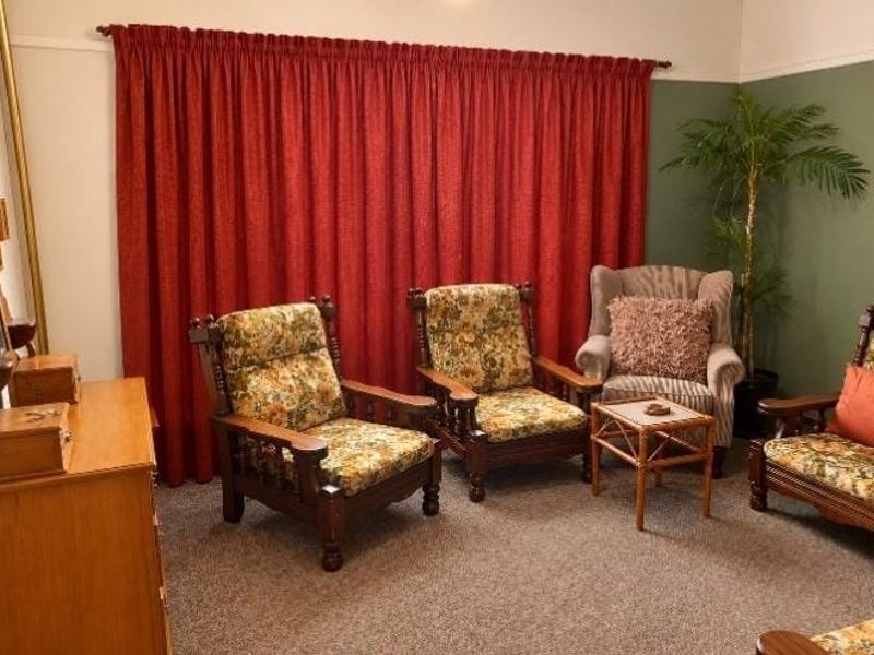 A living room featuring carpet flooring and a classic picture rail, providing a neutral base for potential interior updates.