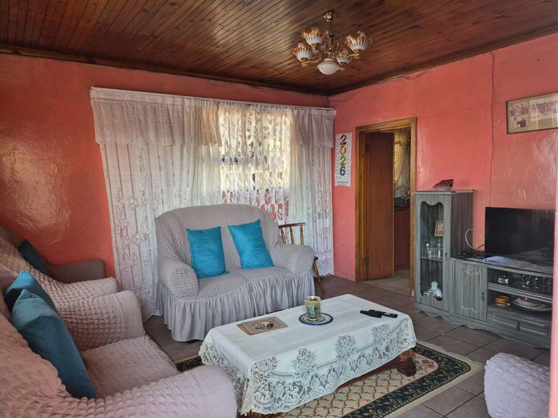 A living room featuring a timber tongue and groove ceiling, tiled flooring, and a traditional layout.