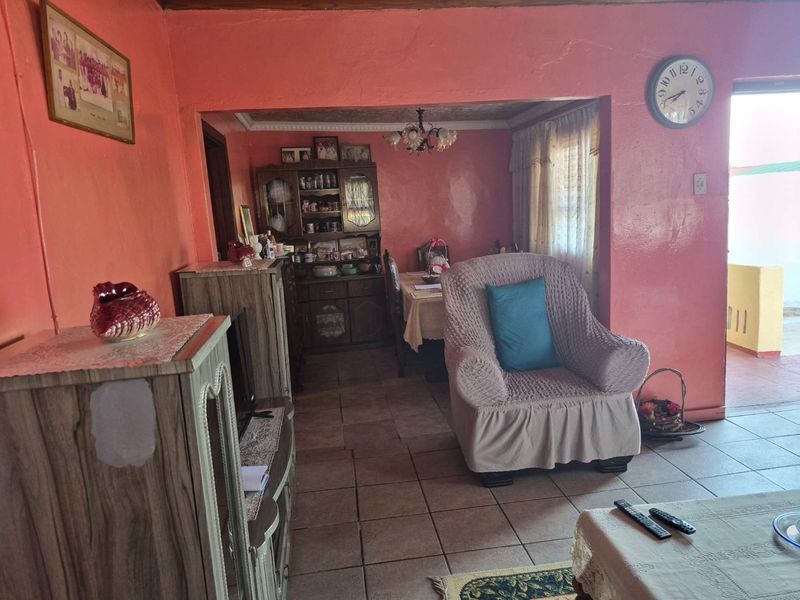 Open plan living and dining area featuring tiled flooring and traditional wall finishes, offering a functional layout with direct access to the exterior.