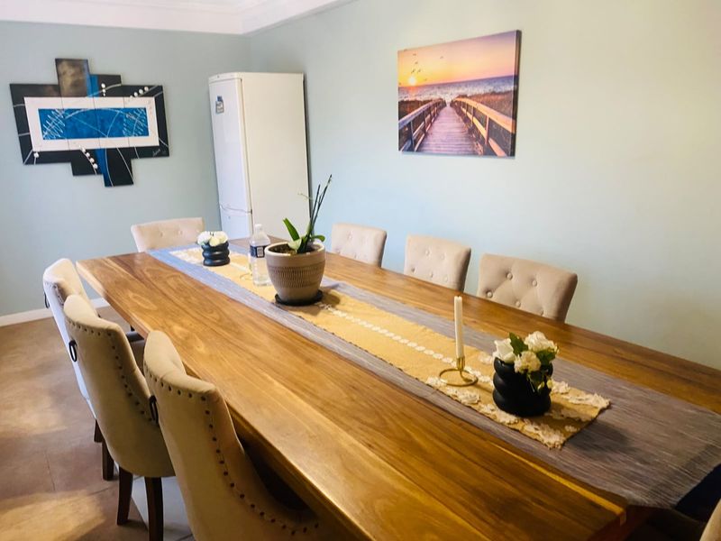 A well-maintained dining room featuring neutral wall tones, coving, and skirting boards, providing a clean and functional space for family meals.