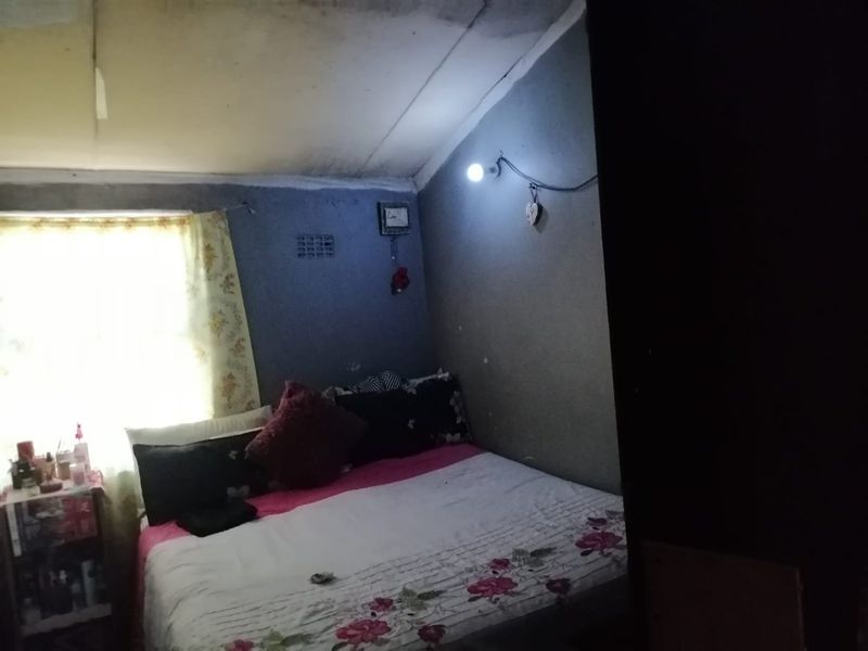 A bedroom featuring a ventilation brick and visible ceiling damage, requiring maintenance and cosmetic updates to improve the living space.