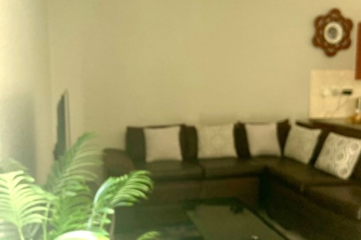 A view of a living room area with neutral walls and a ceiling-mounted light fixture.