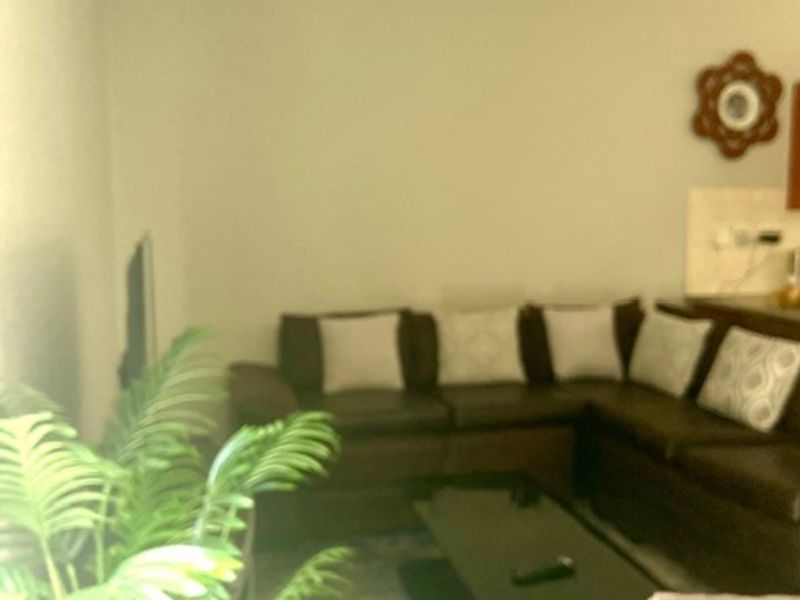 A view of a living room area with neutral walls and a ceiling-mounted light fixture.