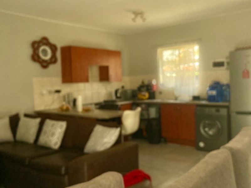 Open plan living and kitchen area featuring built-in cabinetry and tiled flooring, providing a functional layout for daily living.
